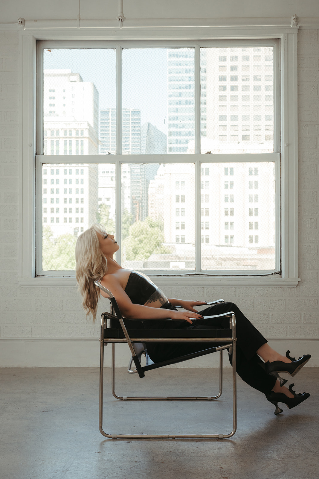 Lady Magdalena reclined in a Wassily chair before a studio window